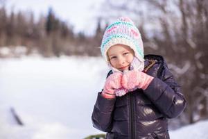 ritratto di poco adorabile contento ragazza nel il neve soleggiato inverno giorno foto