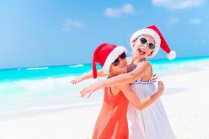 adorabile poco bambini nel Santa cappello durante Natale spiaggia vacanza. nuovo anno su il spiaggia foto