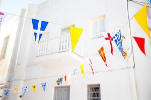 strada con colorato bandiere nel Mykonos, Grecia foto