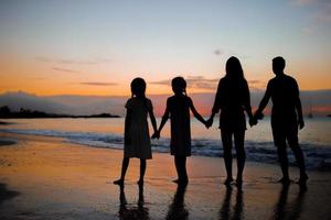 famiglia silhouette nel il tramonto a il spiaggia foto