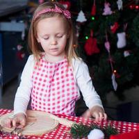 ritratto di poco ragazza cottura al forno Pan di zenzero biscotti per Natale foto