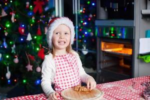 ritratto di adorabile poco ragazza nel il cucina cottura al forno Pan di zenzero foto