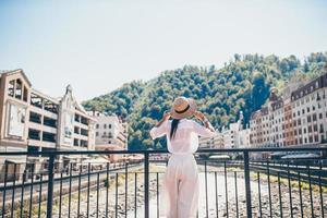 contento ragazza a cappello su il argine di un' montagna fiume nel un' europeo città. foto