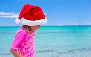 poco adorabile ragazza indossare Santa cappello a tropicale spiaggia foto