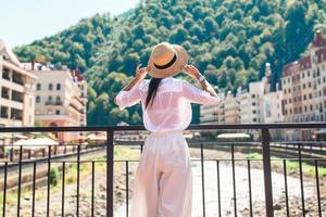 contento ragazza a cappello su il argine di un' montagna fiume nel un' europeo città. foto