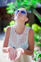 giovane contento donna nel tropicale doccia durante spiaggia vacanza foto