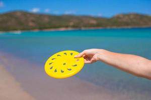 avvicinamento di giallo frisbee su il sfondo di turchese mare foto