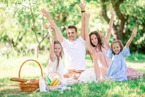 famiglia felice in un picnic nel parco in una giornata di sole foto