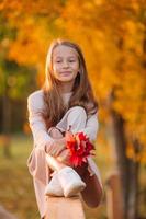 ritratto di adorabile poco ragazza con giallo le foglie mazzo nel autunno foto