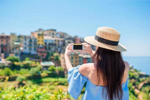 giovane donna prendere un' foto di bellissimo Visualizza a vecchio villaggio nel cinque terre, liguria, Italia. europeo italiano vacanza.