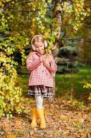 adorabile poco ragazza a bellissimo autunno giorno all'aperto foto