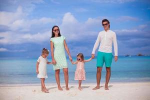 moda famiglia di quattro a piedi di il mare e godere spiaggia vacanza foto