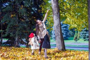 giovane madre e sua adorabile figlia godendo affascinante camminare nel giallo autunno foresta su un' caldo soleggiato giorno foto