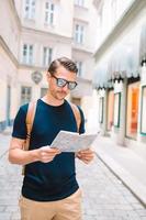uomo turista con un' città carta geografica e zaino nel Europa strada. foto