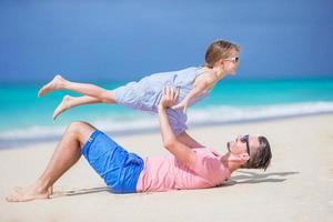 poco ragazza e contento papà avendo divertimento durante spiaggia vacanza foto