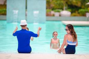 contento famiglia con Due bambini nel all'aperto piscina foto