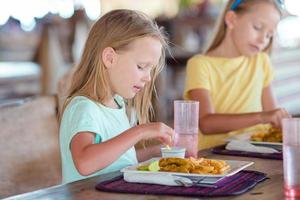 adorabile poco ragazza su prima colazione a all'aperto ristorante foto