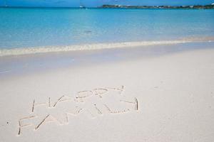 contento famiglia scritto su tropicale spiaggia bianca sabbia foto