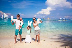 famiglia di quattro su spiaggia vacanza foto