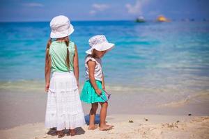 poco adorabile ragazze nel simpatico vestito su bianca spiaggia foto