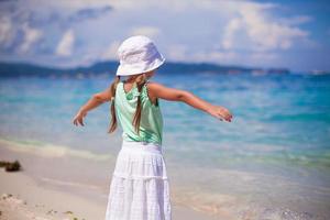 adorabile contento poco ragazza su spiaggia vacanza a piedi squadratura braccio foto