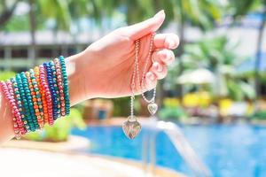 decorazione pendente nel mano al di sopra di il piscina a tropicale ricorrere foto