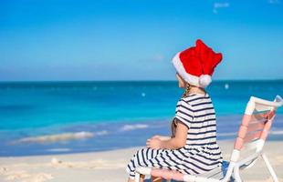 poco ragazza indossare Santa cappello durante tropicale spiaggia vacanza foto