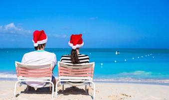 giovane contento coppia nel rosso Santa cappelli su tropicale spiaggia foto