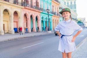 adorabile poco ragazza nel popolare la zona nel vecchio l'Avana, Cuba. ritratto di ragazzo sfondo Vintage ▾ classico americano auto foto
