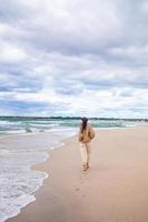 giovane donna su il spiaggia nel il tempesta foto