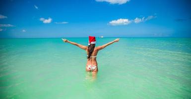 indietro Visualizza di bellissimo ragazza nel Santa cappello a piedi piace un' uccello foto