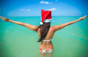 indietro Visualizza di bellissimo ragazza nel Santa cappello a piedi piace un' uccello foto