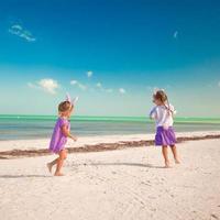 Due poco carino ragazze nel Pasqua orecchie avere divertimento su il esotico spiaggia foto