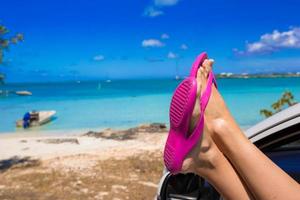 rosa Flip flop a partire dal il finestra di auto su tropicale spiaggia foto