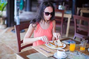 giovane donna avendo prima colazione a all'aperto bar foto