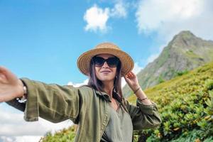 bellissimo contento giovane donna nel montagne nel il sfondo di nebbia foto