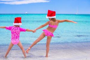 poco ragazze nel Santa cappelli durante estate vacanza foto