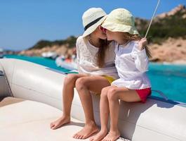 poco carino ragazze godendo andare in barca su barca nel il Aperto mare foto