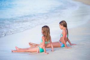 adorabile poco ragazze rilassante su il spiaggia foto