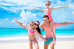 felice bella famiglia sulla spiaggia bianca divertendosi foto