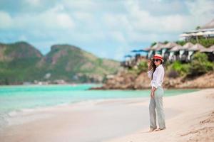 giovane bellissimo donna avendo divertimento su tropicale spiaggia. contento ragazza a piedi a bianca sabbia tropicale spiaggia foto