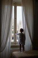 adorabile poco ragazza guardare su il finestra a duomo, Milano, Italia foto