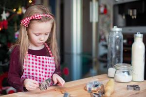 poco adorabile ragazza cottura al forno Natale biscotti a casa foto