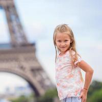 adorabile poco ragazza vicino il eiffel Torre durante estate vacanza nel Parigi foto