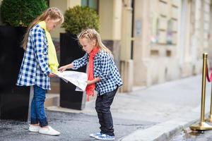 adorabile poco ragazze con carta geografica di europeo città all'aperto foto