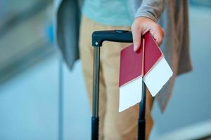 primo piano dell'uomo che tiene i passaporti e la carta d'imbarco all'aeroporto foto