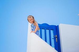 adorabile poco ragazza a vecchio strada di tipico greco tradizionale villaggio foto