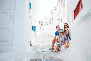 genitori e bambini a strada di tipico greco tradizionale villaggio su mykonos isola, nel Grecia foto