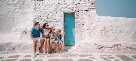 genitori e bambini a strada di tipico greco tradizionale villaggio su mykonos isola, nel Grecia foto