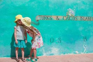 poco bambini vicino grande carta geografica di caraibico isola turchi e caicos dipinto su il parete foto
